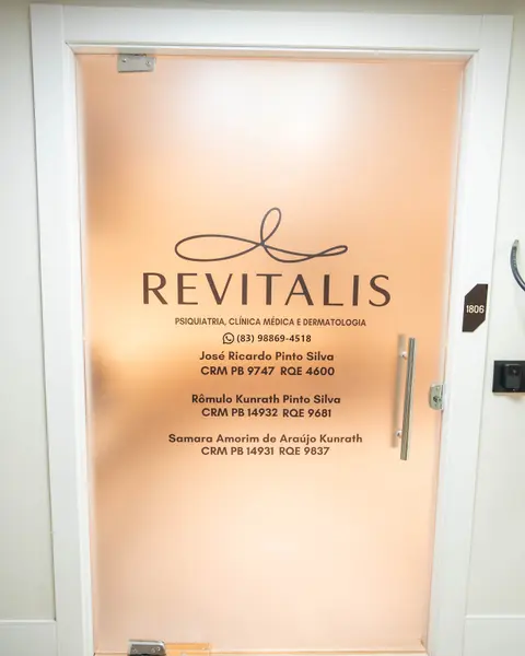 Porta de vidro da Clínica Revitalis com o logotipo e os nomes da equipe médica