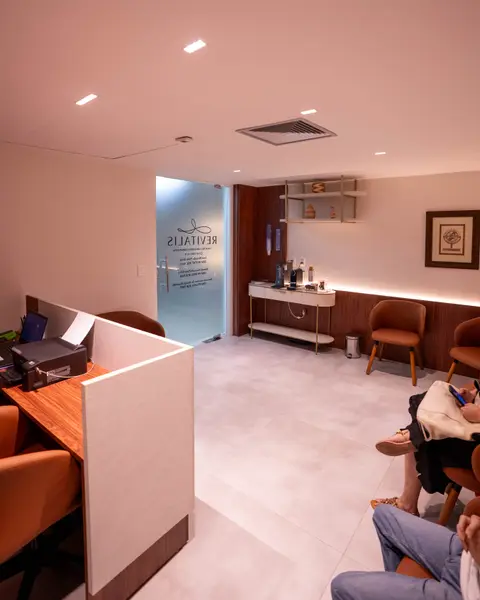 Recepção da Clínica Revitalis com balcão claro e poltronas